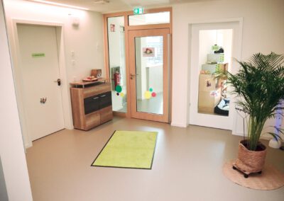 Freundlicher Eingangsbereich mit Pflanze und Türen zu den Gruppen