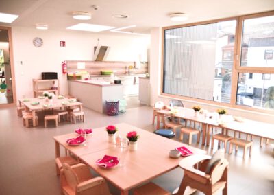 Speisesaal mit kleinen Tischen und Stühlen und Blumen